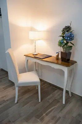 a desk with a chair and a lamp and a plant at Porta Aragonese Luxury Rooms in Palermo
