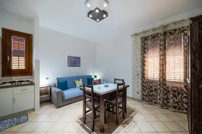 a living room with a table and a couch at Perla di Mare Appartamenti in Castelluzzo