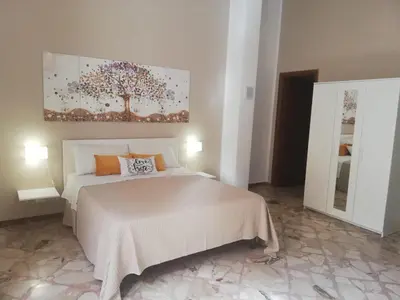 a bedroom with a bed and a painting on the wall at NONNA MARIA Apt 1 or Apt 2 in Terrasini