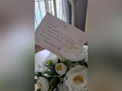 a note sitting on top of a bouquet of flowers at Interno12 in Palermo