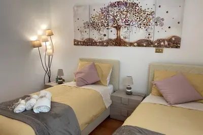 a bedroom with two beds and a painting on the wall at Casa Vacanze Antico Cassaro in Palermo