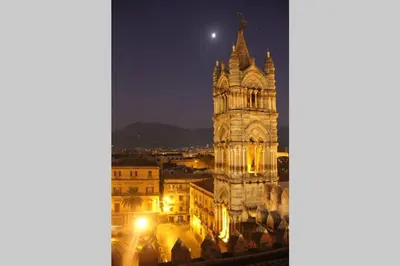 a large building with a clock tower at night at Casa Vacanze Antico Cassaro in Palermo