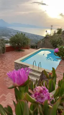 a view of a swimming pool with purple flowers at Villa Verde in Cefalù