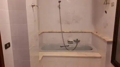 a bath tub with a shower in a bathroom at La Casetta di Nonna Anna in Palermo