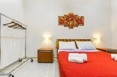 a bedroom with a bed with a red blanket at GuestHost - Corso dei Mille Railway Apartment in Palermo