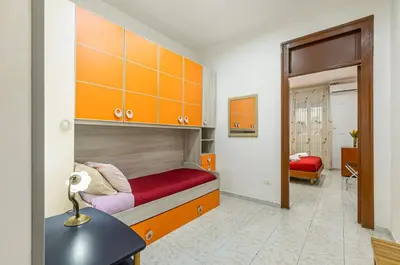 a bedroom with a bunk bed with orange cabinets at GuestHost - Corso dei Mille Railway Apartment in Palermo