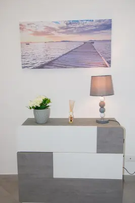 a table with a lamp and a picture of a pier at MONDELLO MANICK MARE in Palermo