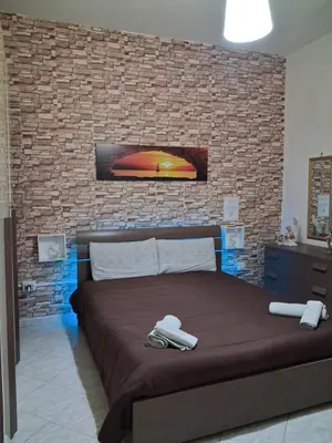 a bedroom with a large bed with a brick wall at Monfenera Apartment 3 in Palermo