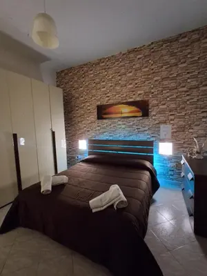 a bedroom with a bed and a brick wall at Monfenera Apartment 3 in Palermo