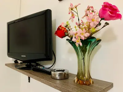a vase of flowers in front of a computer monitor at Monfenera Apartment 3 in Palermo