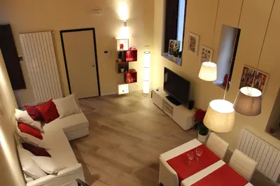 a living room with a white couch and a television at Amalfitani House in Palermo