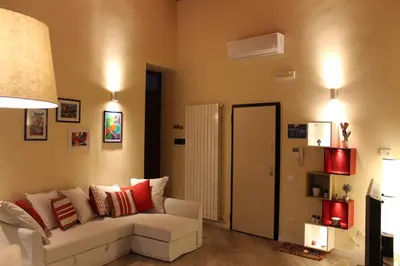 a living room with a white couch and red pillows at Amalfitani House in Palermo