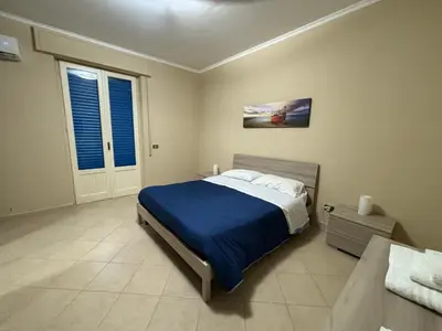a bedroom with a bed with a blue blanket at Casa Olivella in Santa Flavia