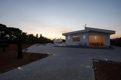 a small white house with a sunset in the background at Villa Cappèddu in Balestrate