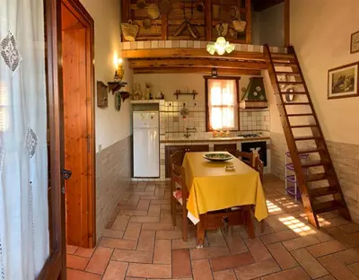a kitchen with a table with a yellow table cloth at Baglio Cracchiolo Casa Baldo in San Vito lo Capo