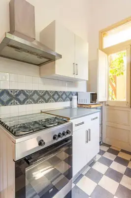 a white kitchen with a stove top oven at mondello sea view beach apartment in Palermo