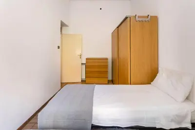 a bedroom with a bed and a wooden cabinet at mondello sea view beach apartment in Palermo