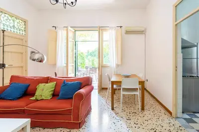a living room with a red couch and a table at mondello sea view beach apartment in Palermo