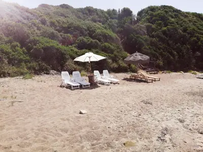 a group of chairs and an umbrella on a beach at Villa Giorgia 2020 in Cefalù