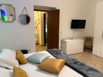 a bedroom with a bed with pillows and a television at Briogna by Maravigghia Palermo in Palermo