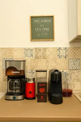 a kitchen counter with a coffee maker and a coffee pot at Briogna by Maravigghia Palermo in Palermo