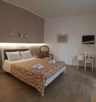 a bedroom with a bed and a chair and a television at Dietro il massimo in Palermo