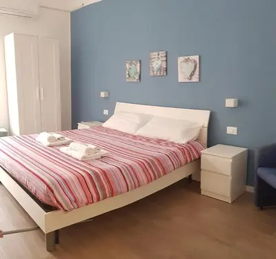 a bedroom with a large bed with a blue wall at Dietro il massimo in Palermo