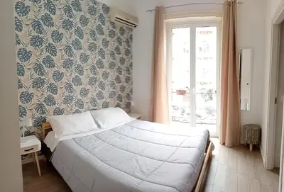 a bedroom with a white bed and a window at Dietro il massimo in Palermo