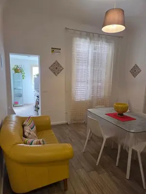 a living room with a yellow couch and a table at Dietro il massimo in Palermo