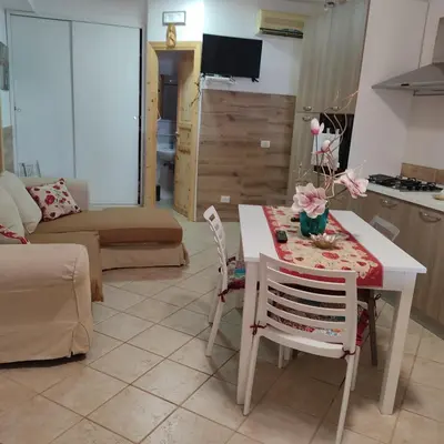 a kitchen and living room with a table and chairs at Baglio Cracchiolo da Tuzzo - Casa Il Limone in San Vito lo Capo