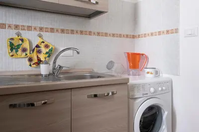 a kitchen with a sink and a washing machine at Casa Gagliani, a Liberty house in the old downtown in Palermo