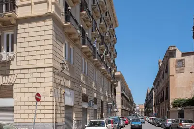 a building on the side of a street with parked cars at Casa Gagliani, a Liberty house in the old downtown in Palermo