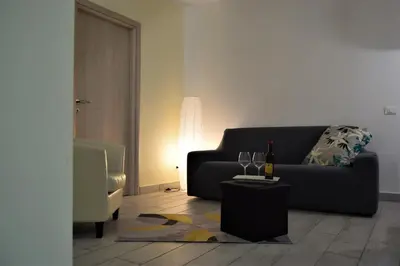 a living room with a black couch and a table at L'Antico Borgo di Segesta in Calatafimi