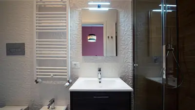 a bathroom with a sink and a shower and a mirror at Zefiro Suites in Palermo