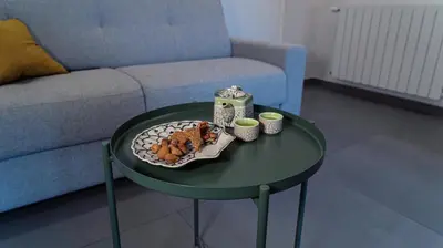 a table with a plate of food on it with a couch at Zefiro Suites in Palermo