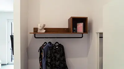 a shelf in a hallway with hangers at Zefiro Suites in Palermo