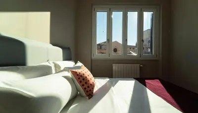 a living room with a white couch and a window at Zefiro Suites in Palermo