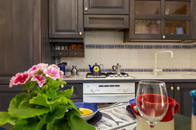 a kitchen with a table with a glass of wine at VILLA GIAGGIA - VICINO IL MARE in San Vito lo Capo