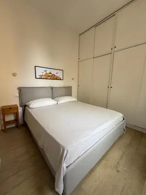 a bedroom with a large white bed with white cabinets at B&B Babbaluci - Centro Storico in Palermo