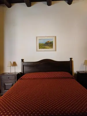 a bedroom with a bed and a picture on the wall at Agriturismo Masseria La Chiusa in San Giuseppe Jato