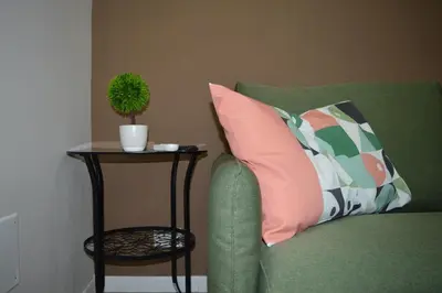 a green couch with a pillow and a plant on a table at Antico vicolo di ballarò in Palermo