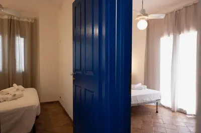 a blue door in a room with a bed at Villa Blumarine sul mare in San Vito lo Capo