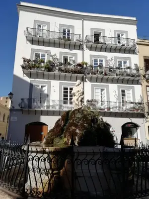 a white building with a statue in front of it at A Casa del Genio in Palermo