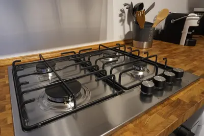 a stove top with four burners on a kitchen counter at A Casa del Genio in Palermo