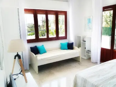 a white room with a bench in front of a window at villa coral mondello in Palermo