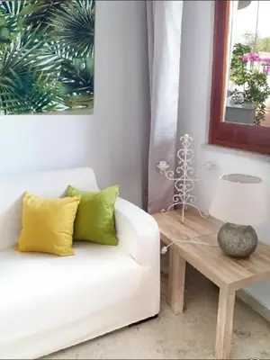 a living room with a white couch and a table at villa coral mondello in Palermo