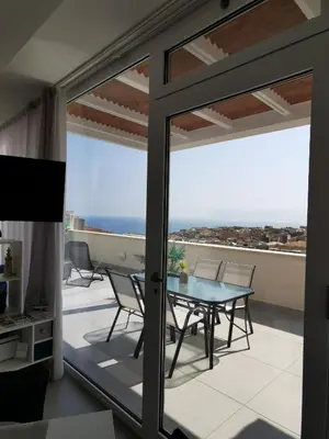 a glass door leading to a balcony with a table and chairs at Appartamento Sul Golfo in Castellammare del Golfo