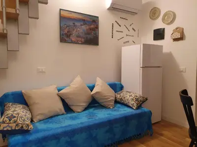a blue couch in a living room with a refrigerator at HoliDay in Palermo