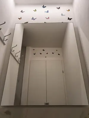 a mirror in a room with butterflies on the ceiling at HoliDay in Palermo