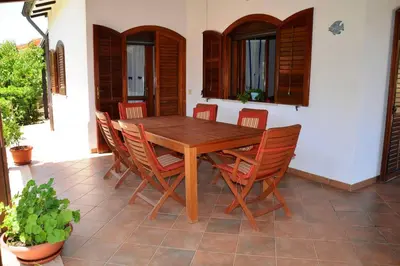 a wooden table and chairs on a patio at Villa Fraginesi in Castellammare del Golfo